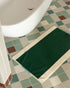 Dark green bath mat from Suite 702 in aqua color, 50x80 inches, showing soft plush fabric and textured surface.