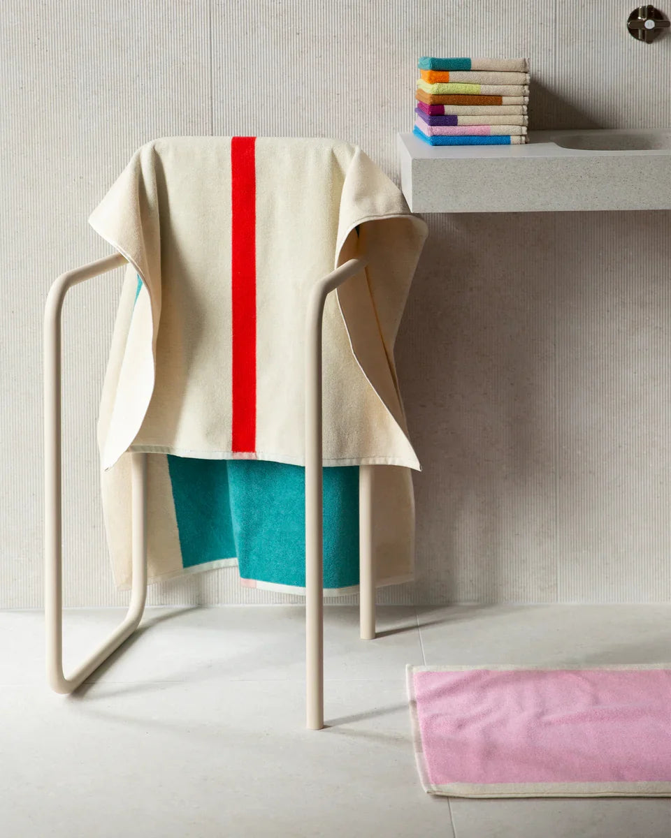 Pink Olive bath mat, 50x80 inches, soft and plush bath towel from Suite 702, displayed on a bathroom floor.