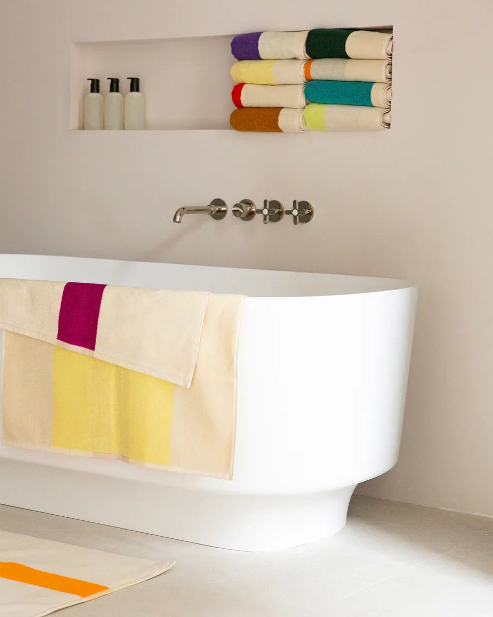Yellow and fuchsia bath towel from Suite 702, 70x140 inches, soft and plush fabric for comfortable drying.