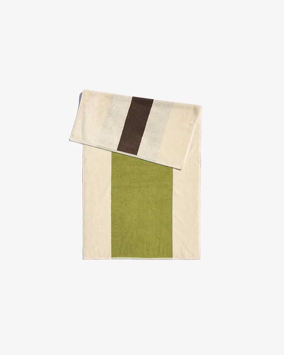 Brown towel from Suite 702 with lime accents, soft fabric, and a textured surface, perfect for bath or beach use.