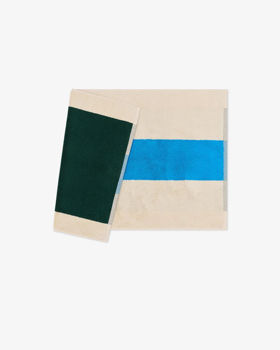Dark green bath mat from Suite 702, 50x80 inches, with plush texture and aqua color, displayed on a bathroom floor.