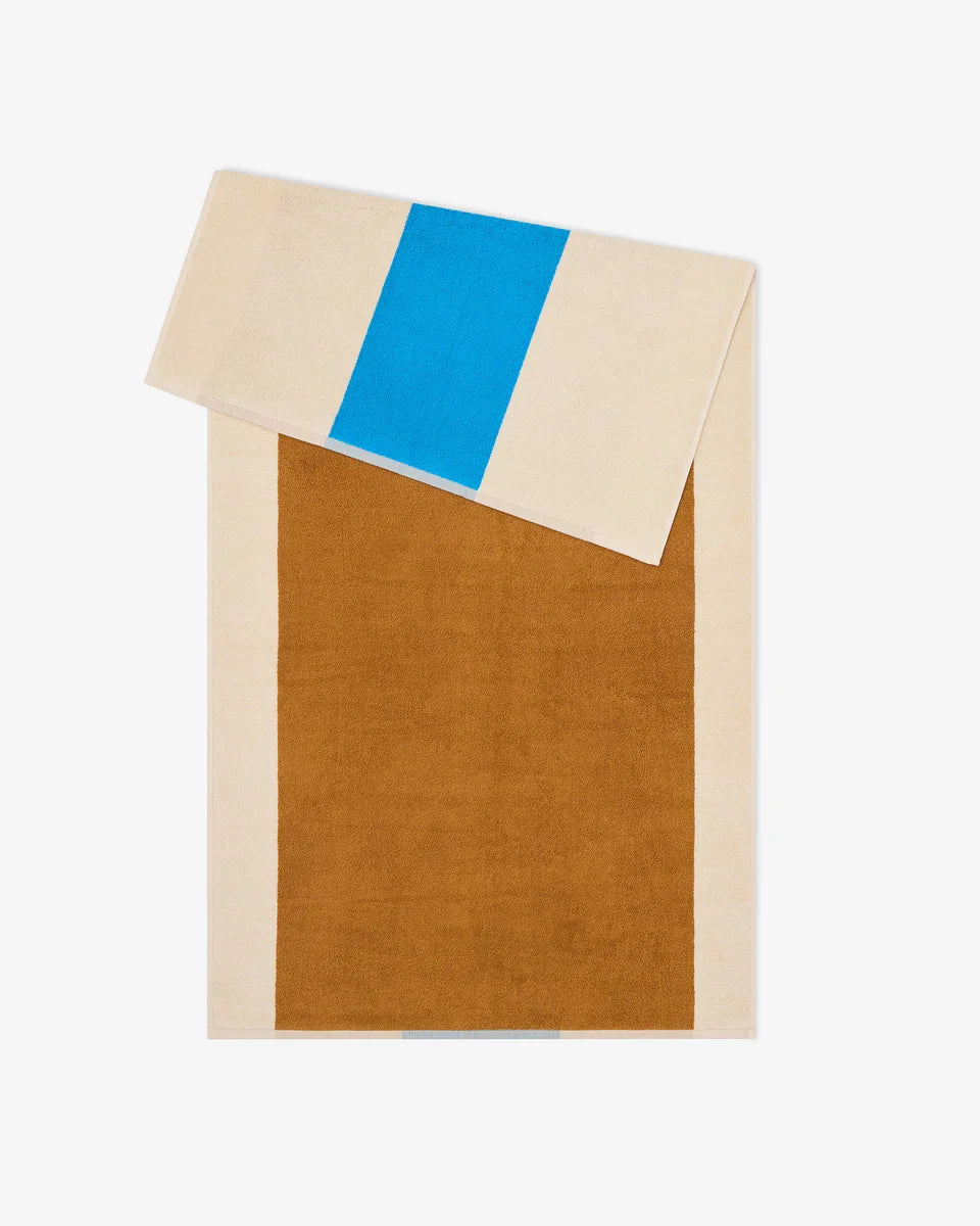 Aqua and toffee-colored bath towel from Suite 702, 70x140 inches, showing soft, plush fabric with folded edges.