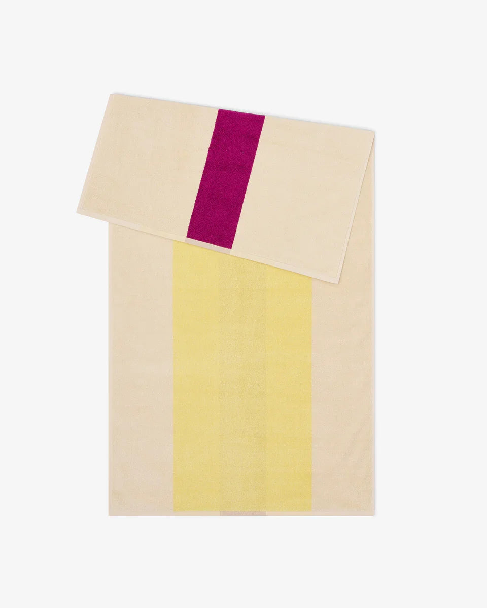 Yellow and fuchsia bath towel from Suite 702, 70x140 inches, showing soft fabric and vibrant color details.
