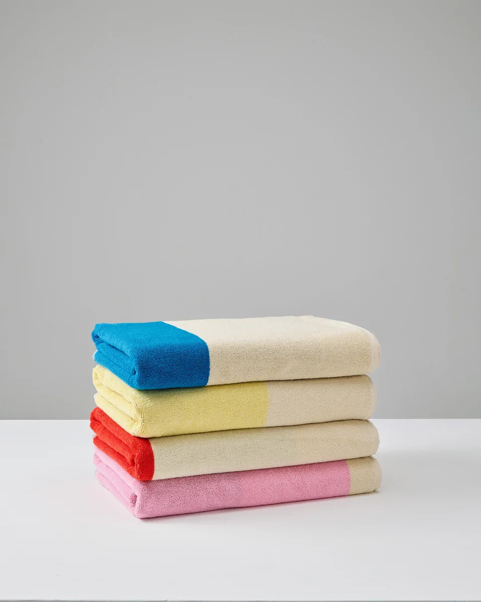 Stacked Aqua and Toffee bath towels from Suite 702, plush 70x140 inches, showing soft, absorbent fabric and vibrant colors.