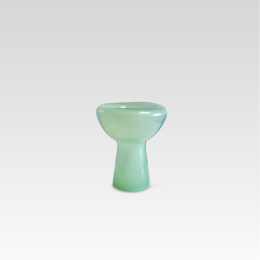 A green, glass decorative phantom dish with an irregular, organic shape, handmade and displaying possible magical bubbles or unique features.