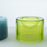 A translucent lime green wetbowl with a small recessed bowl inside, shown on a light gray surface with part of a blue wetbowl is visible on the left.