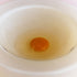 A cracked egg appears inside a white -vanilla bowl, closeup